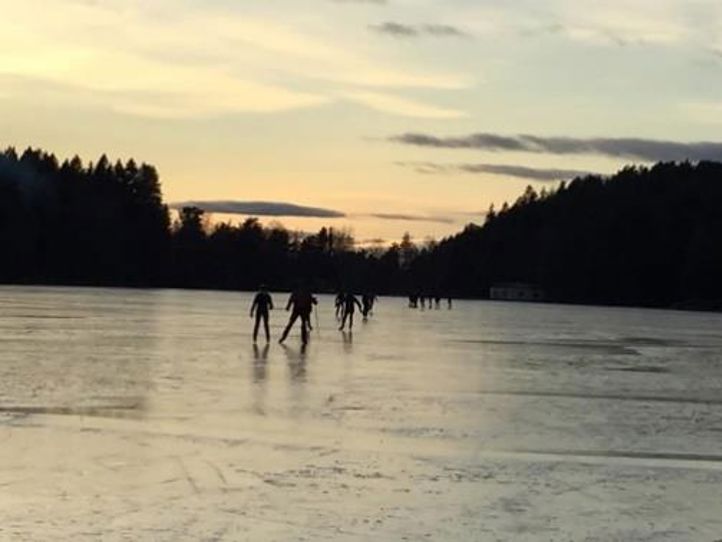 Elever på islagt vann i solnedgang